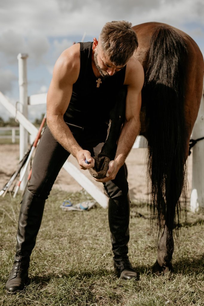 Farrier working on a hoof in sunlight