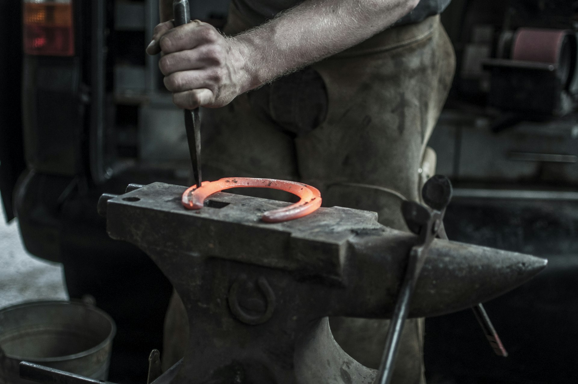 Craftsman forging a horseshoe on an anvil